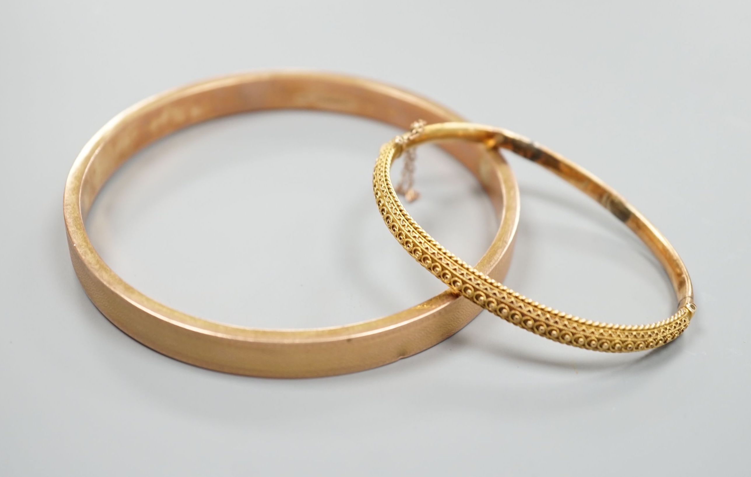 A 9ct gold bangle, 14.5 grams and a Victorian 15ct hinged bangle(a.f.), 7.8 grams.